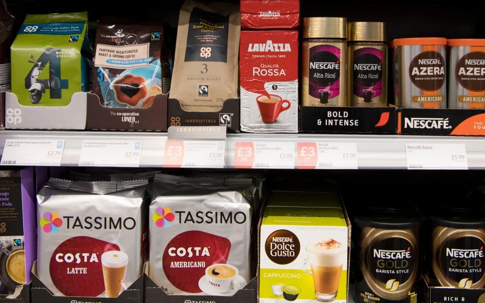 A supermarket shelf displaying various coffee products including instant coffee and commercial blends, highlighting the economic significance of Robusta.