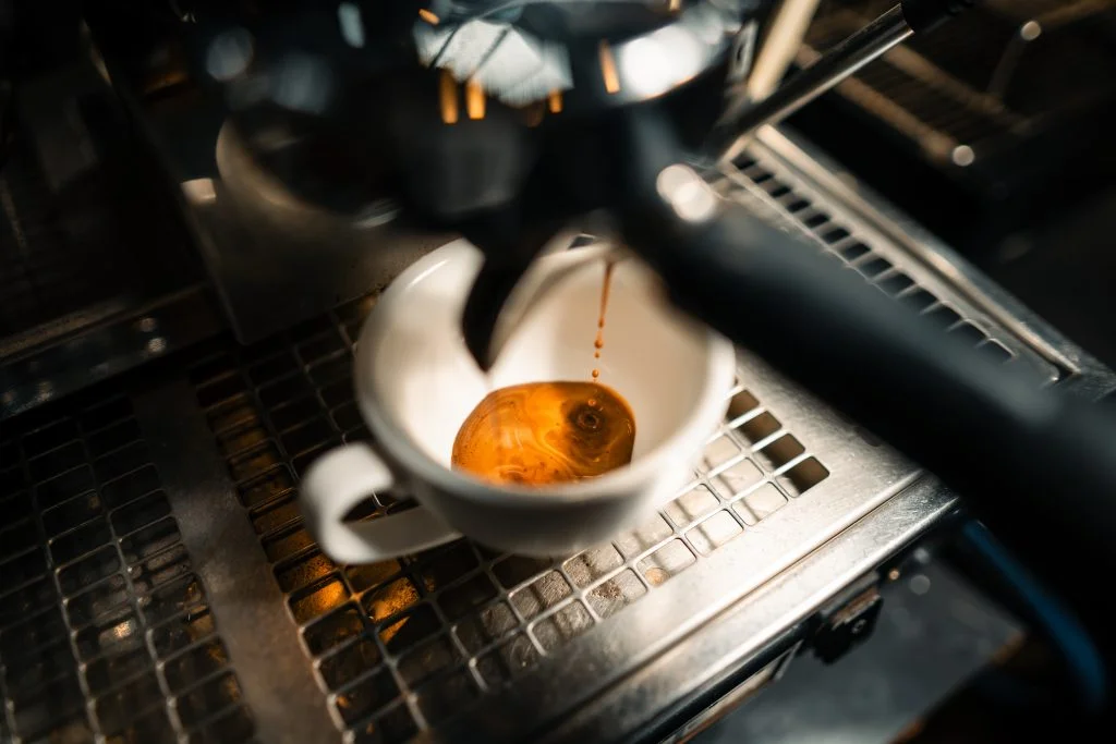 Espresso vs Ristretto Smackdown: Which Bold Shot Wins Your Morning? 5 Close-up of espresso being extracted into a white cup from an espresso machine.
