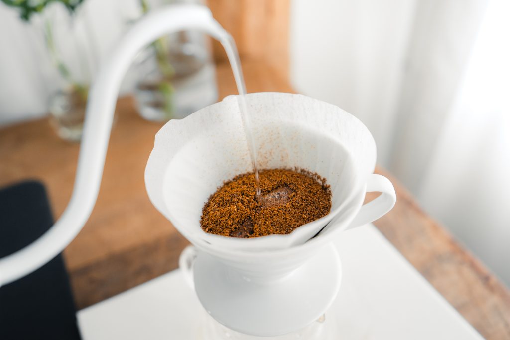 Cận cảnh quá trình pha cà phê pour over với nước nóng được đổ lên bột cà phê