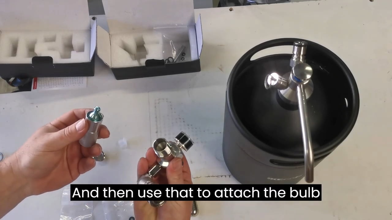 Hands holding gas regulator parts and attaching bulb to keg system