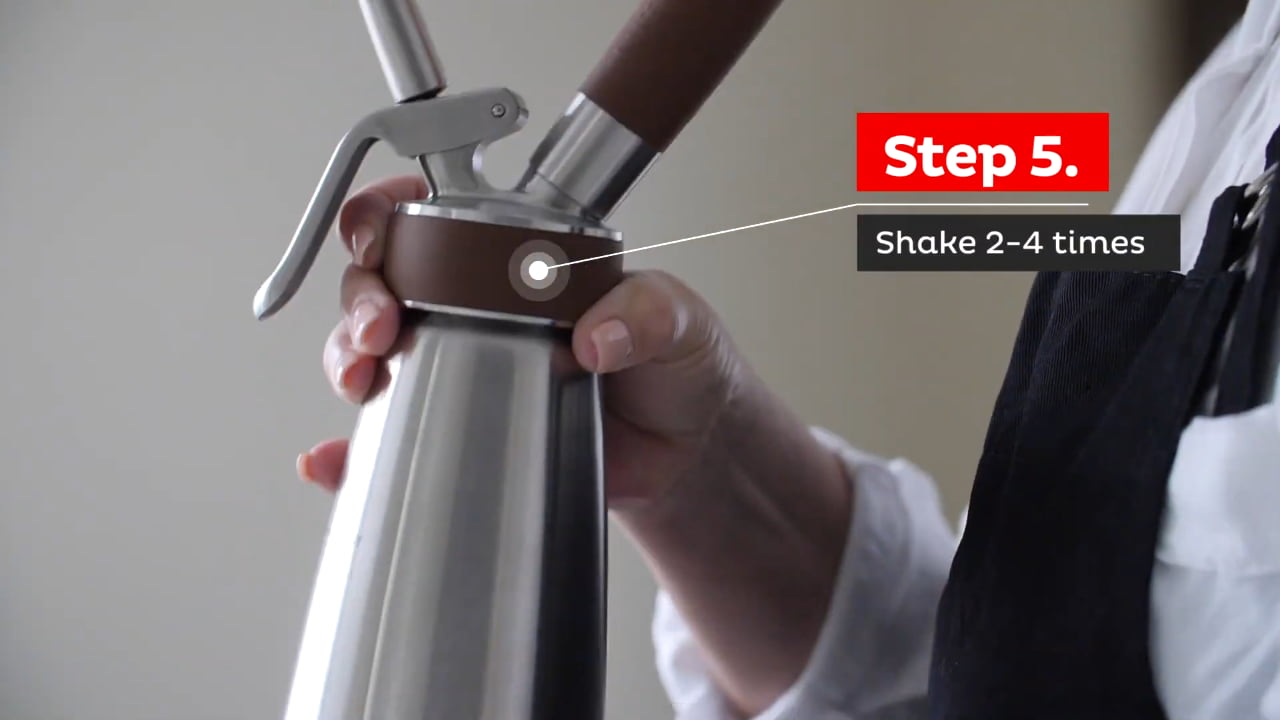 Hand holding nitro coffee maker, demonstrating shaking step