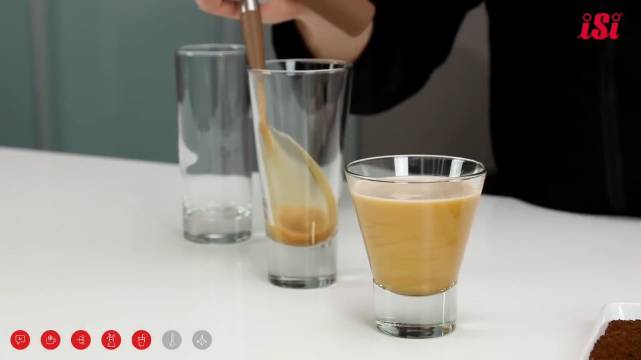 Pouring nitro coffee into glass, showing cascading effect and creamy texture