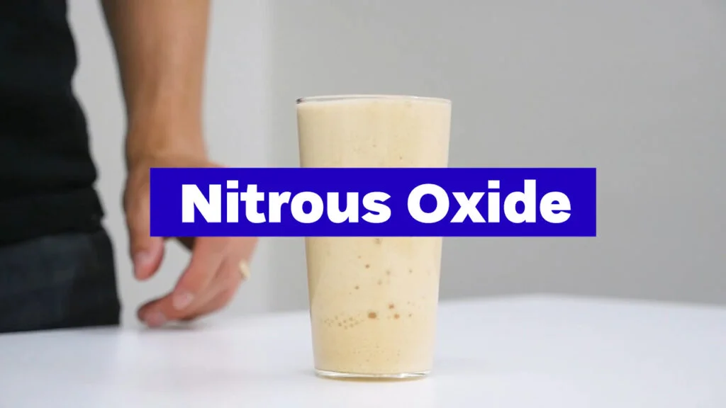 Glass of thick, creamy nitrous oxide-infused coffee with 'Nitrous Oxide' text overlay