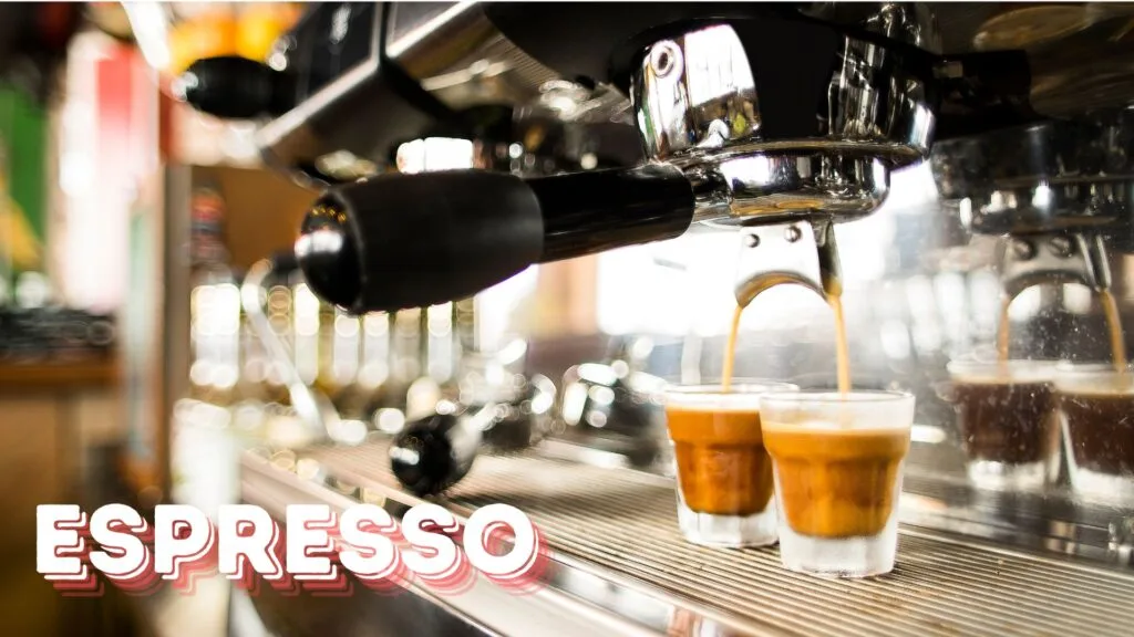 Professional espresso machine extracting a double shot of espresso into two clear glass cups, showing the golden crema forming on top with beautiful bokeh lighting effects in the background.