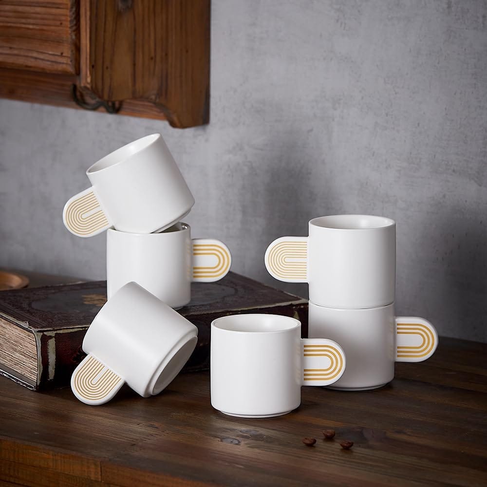 Finding Perfect Cortado Cup: A Journey Worth Taking 13 White ceramic 4.5 oz demitasse cups with distinctive gold striped handles arranged artistically on wooden surface