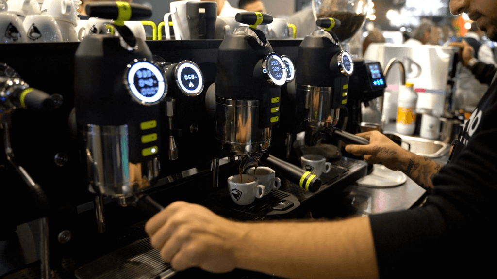 The Origin of the Flat White: A Love Letter to Coffee's Silkiest Story 8 Modern espresso machine with digital displays and LED indicators being operated by professional barista, showcasing contemporary flat white preparation technology