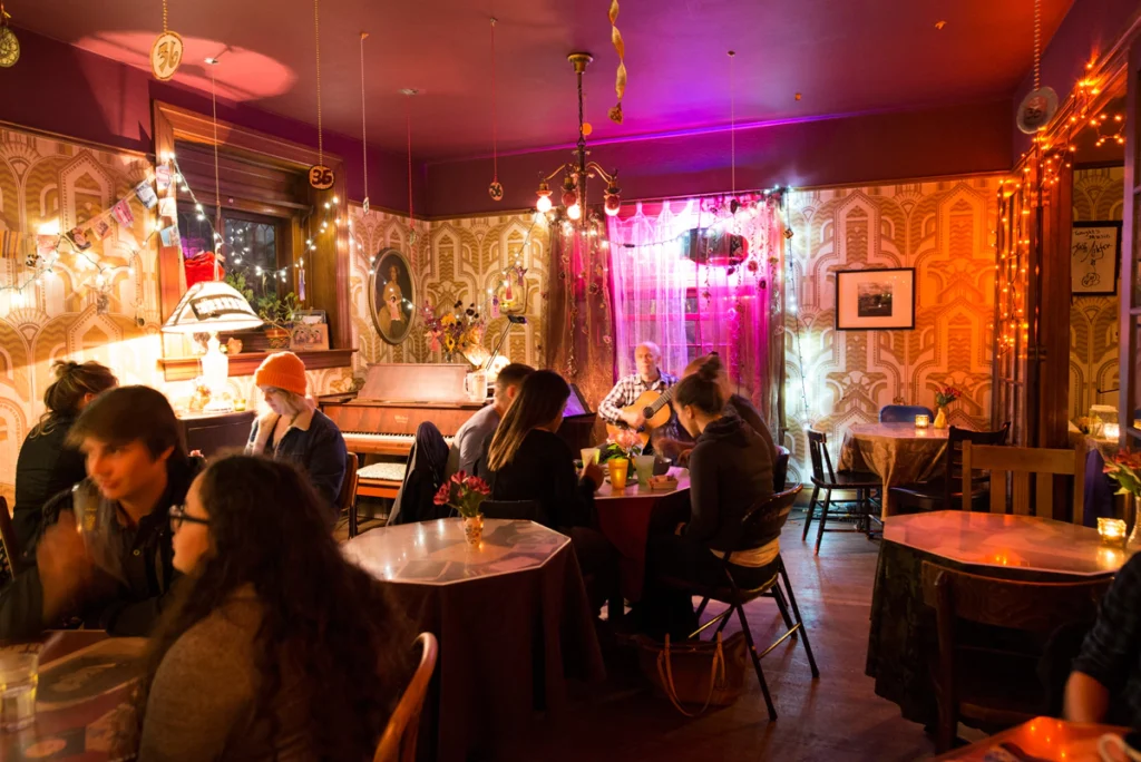 Finding Your Perfect Coffee Shop Near Me: A Blend of Beans, Brews, and Belonging 8 Cozy interior of Rimsky-Korsakoffee House in Portland, OR, featuring eclectic decor, warm lighting, live acoustic music, and intimate seating areas.