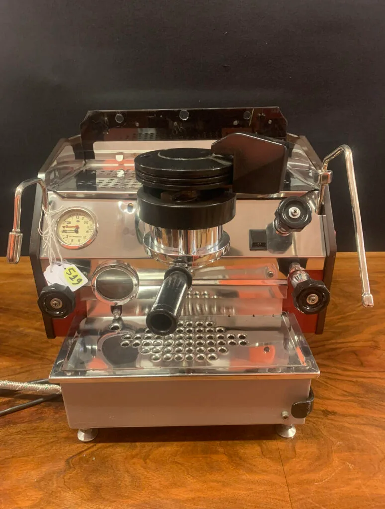 Rare transparent La Marzocco GS espresso machine from the 1970s showing internal components, pressure gauge, and chrome fixtures - a pioneering model in commercial coffee brewing