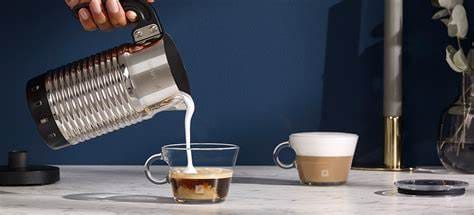 Aeroccino Milk Frother Secret Of Perfect Home Café Foam 6 Aeroccino milk frother pouring freshly frothed milk into an espresso cup on marble countertop against blue background