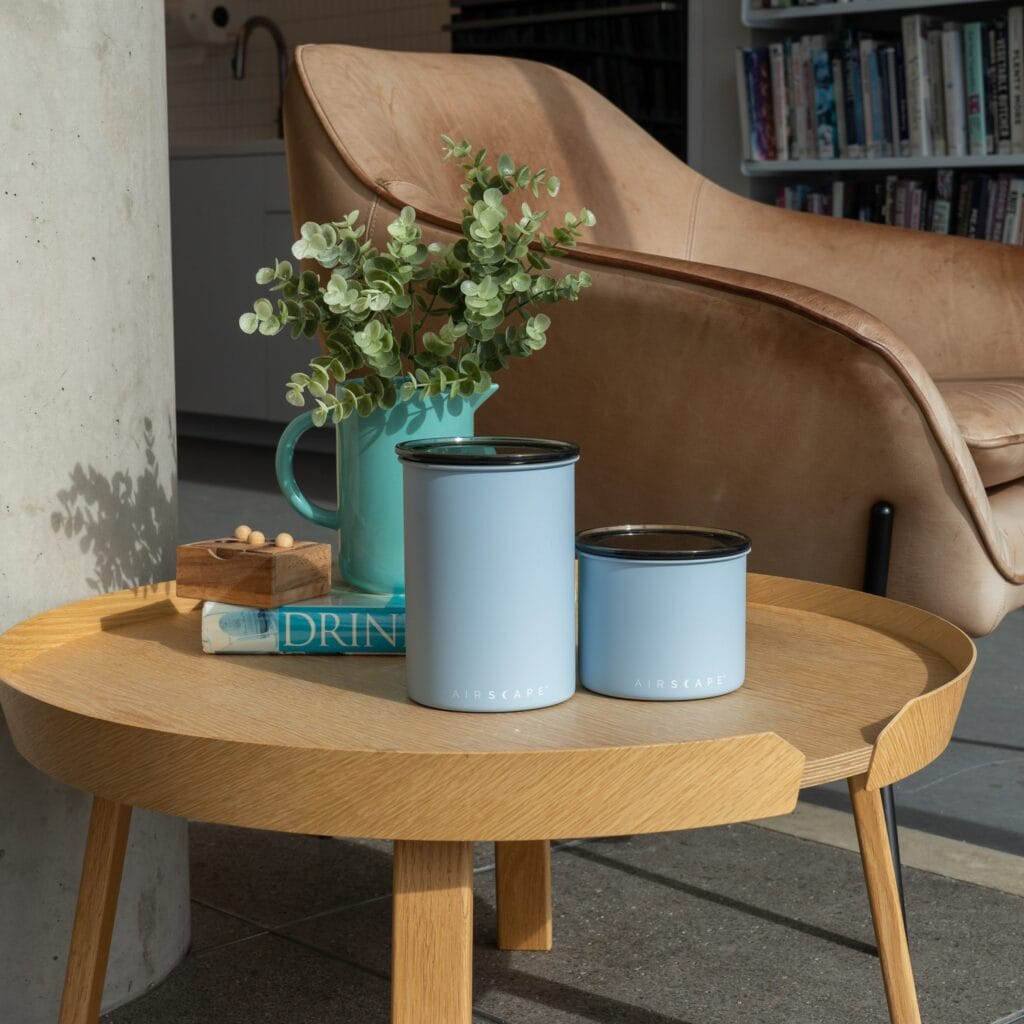 Airscape Coffee Canister: The Revolutionary Technology That Locks in Coffee Freshness 14 Airscape coffee canisters in light blue displayed in stylish living space, showing how these storage containers preserve coffee freshness and flavor while complementing modern home decor