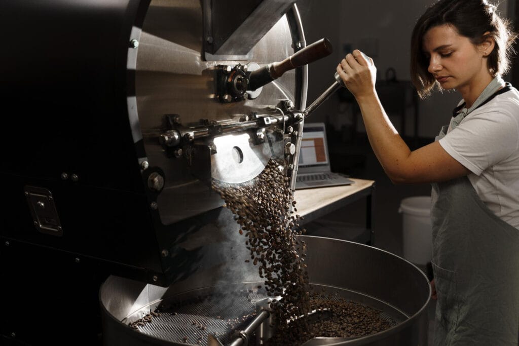 Professional coffee roaster operating commercial roasting equipment at best coffee roastery