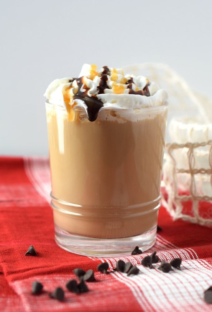 What Is a Caramel Mocha Latte and How Is It Made? 7 Glass of caramel mocha latte topped with whipped cream and drizzled with caramel and chocolate syrup