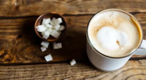 Close-up of a Starbucks cup with an iced coffee featuring coconut milk foam on top.