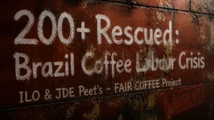 Chalk typography on weathered wall reading 200+ Rescued Brazil Coffee Labour Crisis with ILO and JDE Peet's text, highlighting FAIR COFFEE project